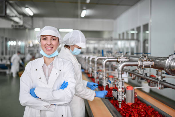 Personal con guantes y cofias en empresa que procesa alimentos. Abadi Distribución de Alimentos se alinea a estas prácticas de inocuidad.